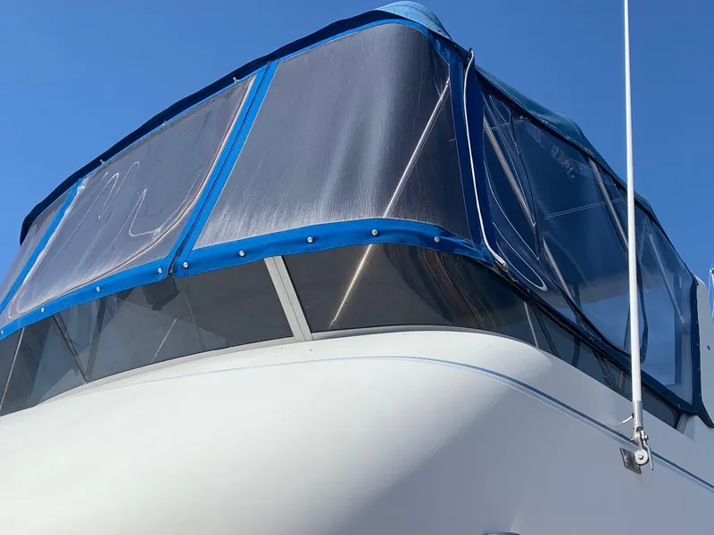Slide: The Image of 1992 Carver 33 Aft Cabin boat with blue canopy against clear sky. - 28