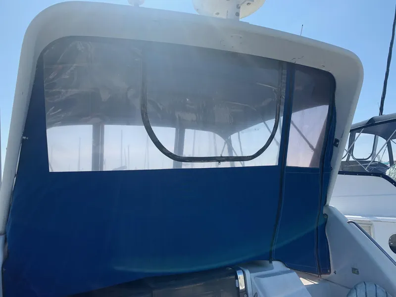 Slide: The Image of 1992 Carver 33 Aft Cabin boat with blue canvas enclosure, docked under clear sky. - 29