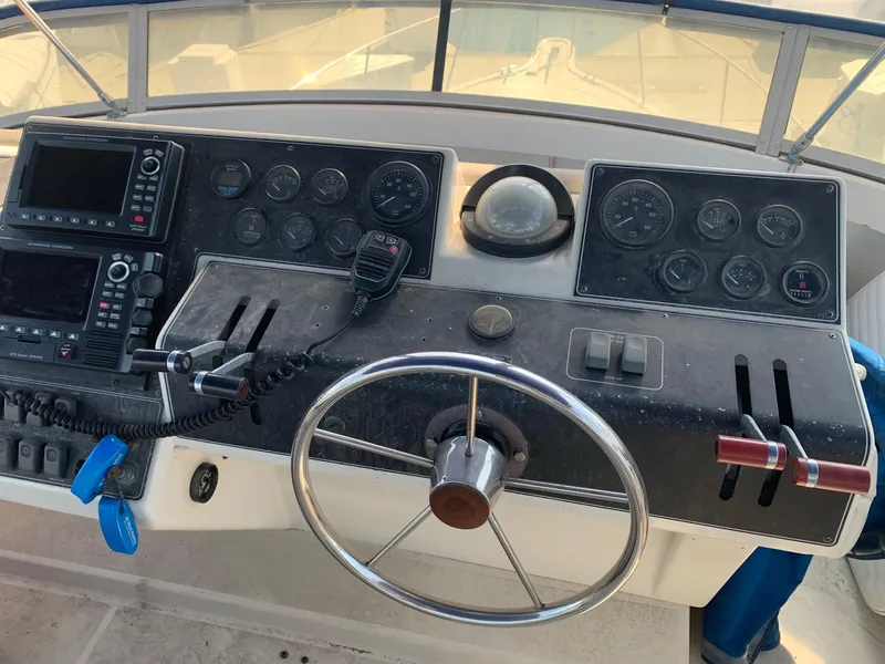 Slide: The Image of 1992 Carver 33 Aft Cabin helm with steering wheel, gauges, and navigation equipment. - 32
