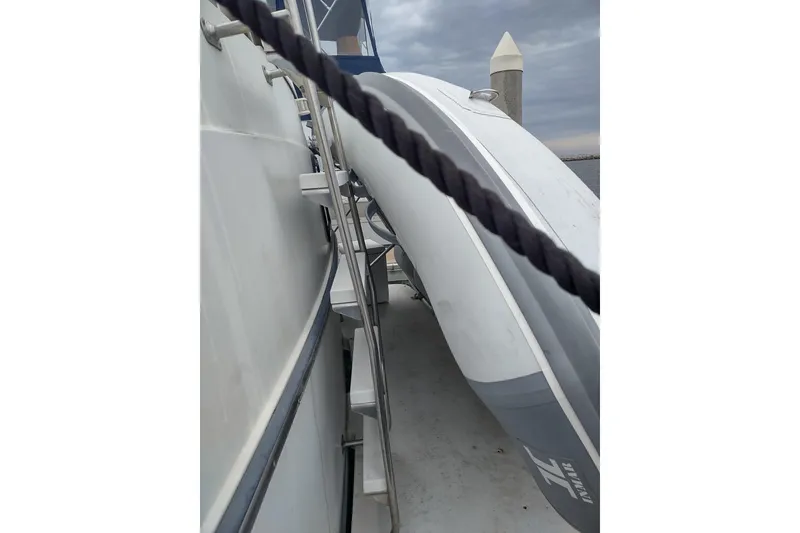 Slide: The Image of 1992 Carver 33 Aft Cabin Motor Yacht with attached inflatable dinghy, docked under cloudy skies. - 44