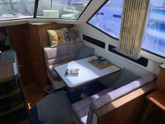 Slide: The Image of 1992 Carver 33 Aft Cabin interior with cozy seating and table, featuring nautical decor. - 6