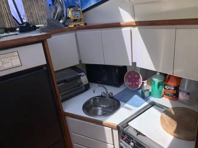 Slide: The Image of 1992 Carver 33 Aft Cabin kitchen with sink, microwave, and storage cabinets. - 12