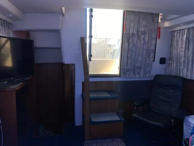 Slide: The Image of Interior of 1992 Carver 33 Aft Cabin with stairs, TV, and seating area. - 16