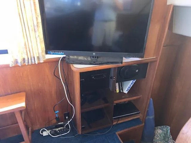 Slide: The Image of Entertainment setup in a 1992 Carver 33 Aft Cabin with TV and shelving. - 17