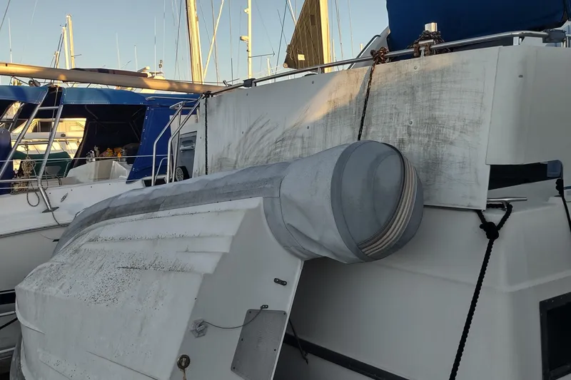 Slide: The Image of 1992 Carver 33 Aft Cabin yacht docked with visible wear and covered equipment. - 37