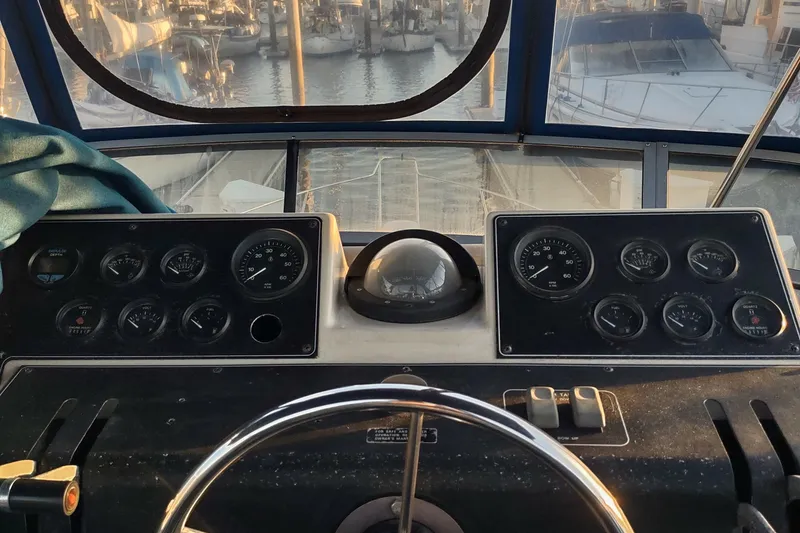 Slide: The Image of 1992 Carver 33 Aft Cabin helm with gauges and steering wheel, docked at marina. - 40