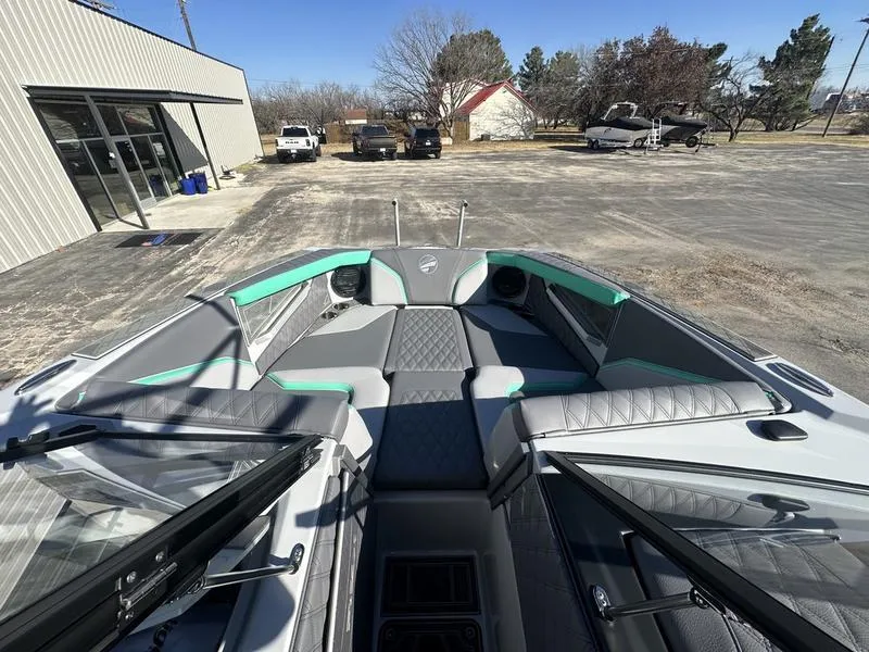 Slide: The Image of 2025 Tigé 24RZX boat interior with gray and teal seating, parked outdoors. - 4