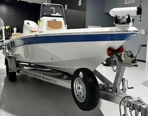 Slide: The Image of 2025 NauticStar 214 Bay boat on trailer in showroom, featuring sleek design and modern equipment. - 1