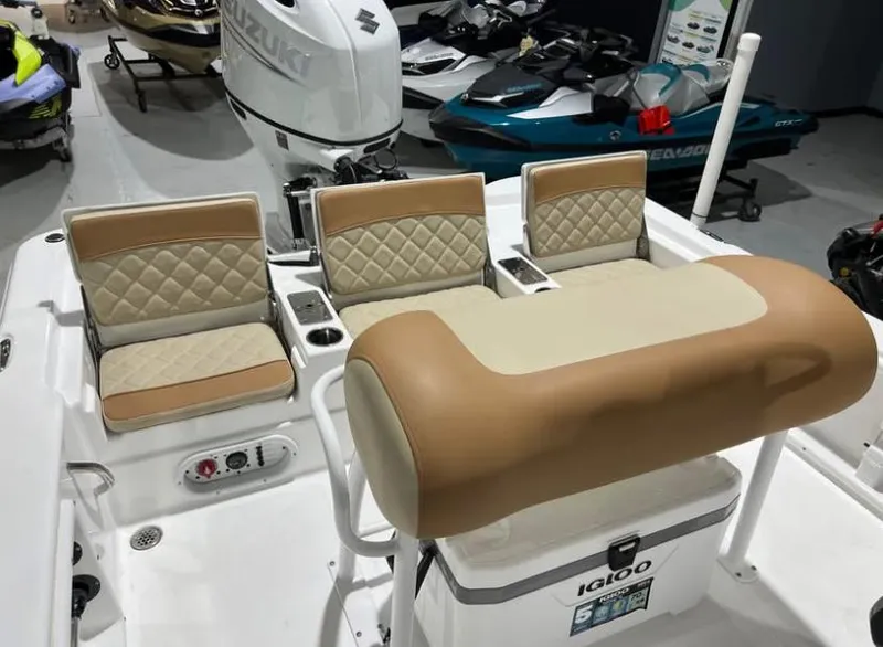 Slide: The Image of 2025 NauticStar 214 Bay boat interior with tan seating and Igloo cooler. - 2