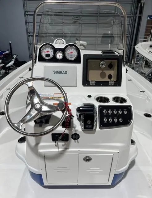 Slide: The Image of 2025 NauticStar 214 Bay boat console with steering wheel and navigation controls. - 3