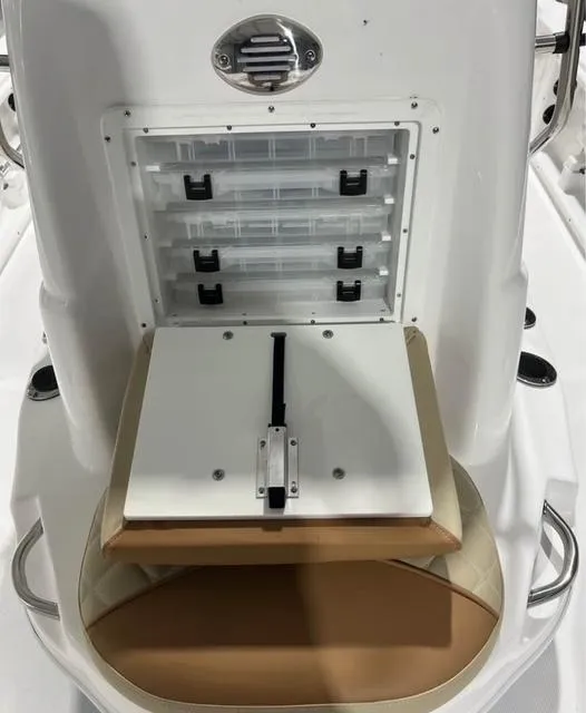 Slide: The Image of 2025 NauticStar 214 Bay boat storage compartment with tackle boxes and seating. - 4