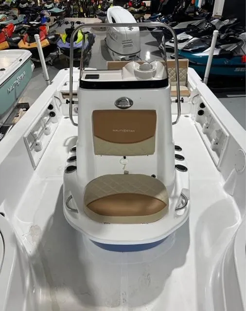 Slide: The Image of 2025 NauticStar 214 Bay boat interior with seating and console, displayed in showroom. - 5