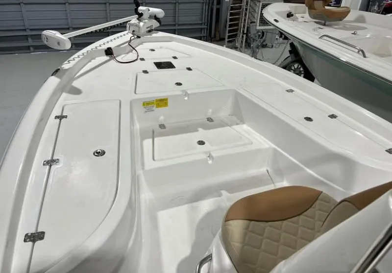 Slide: The Image of 2025 NauticStar 214 Bay boat interior with white deck and tan seating. - 6