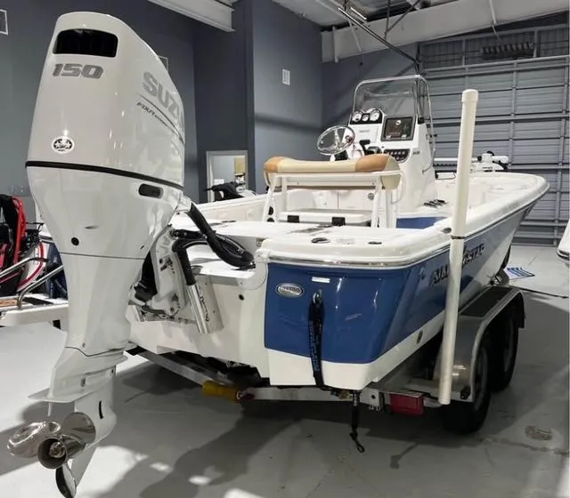Slide: The Image of 2025 NauticStar 214 Bay boat with Suzuki 150 engine in showroom. - 7