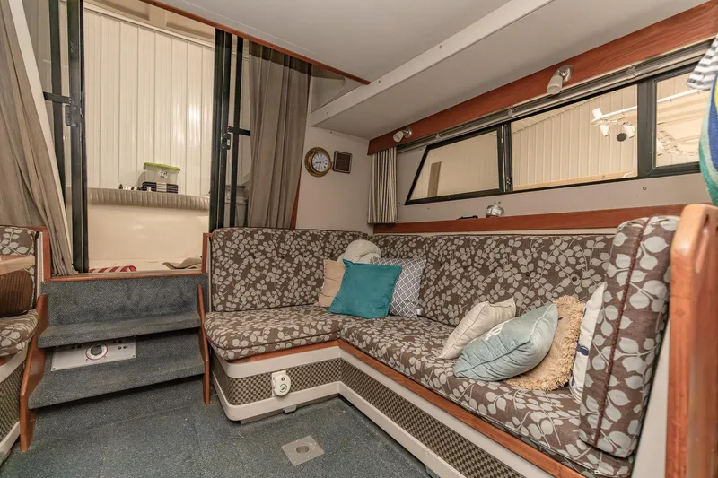 Slide: The Image of 1987 Carver 3697 Mariner interior with floral-patterned seating and decorative pillows. - 11