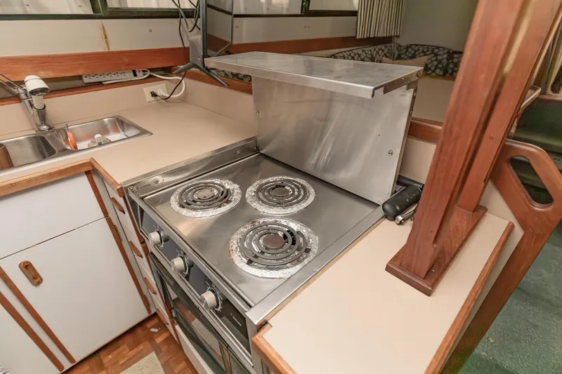 Slide: The Image of 1987 Carver 3697 Mariner kitchen with stove and sink, featuring wood accents. - 15