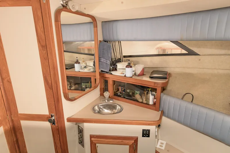 Slide: The Image of 1987 Carver 3697 Mariner interior with sink, mirror, and wooden cabinetry. - 29