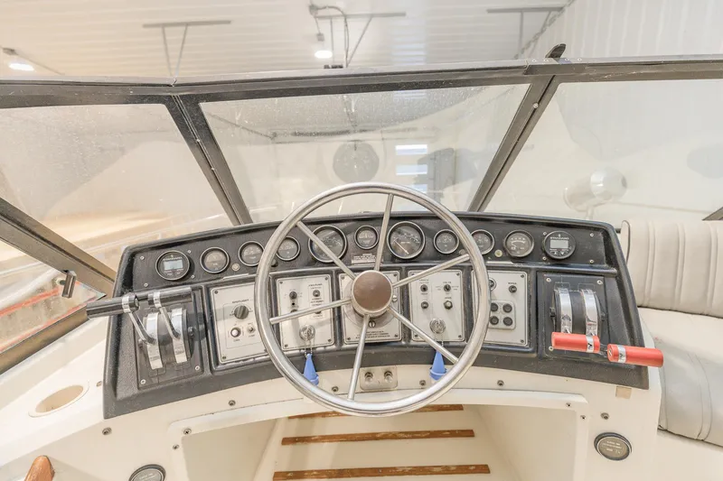 Slide: The Image of 1987 Carver 3697 Mariner boat dashboard with steering wheel and control panel. - 38