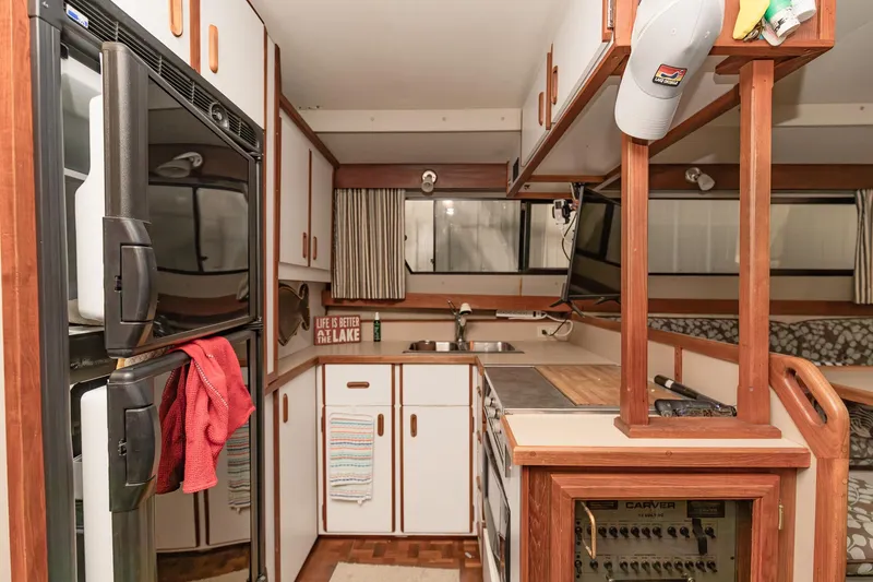 Slide: The Image of 1987 Carver 3697 Mariner interior kitchen with wood accents and modern appliances. - 12