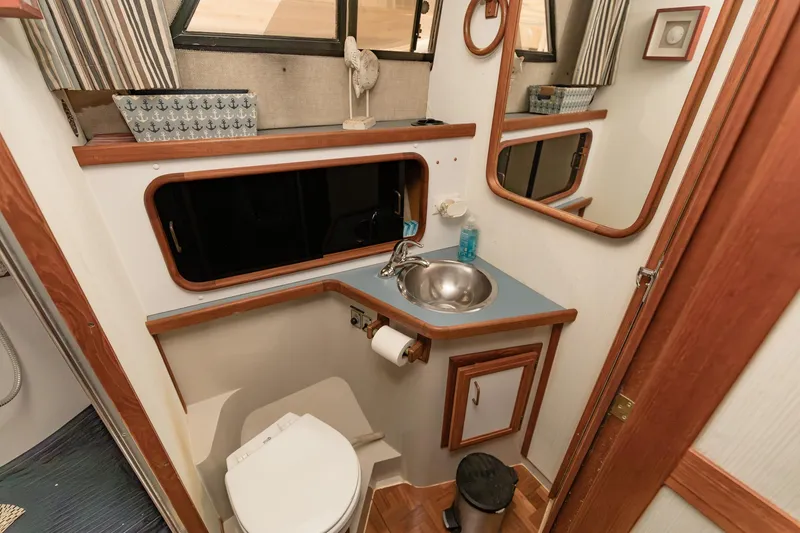 Slide: The Image of 1987 Carver 3697 Mariner bathroom with sink, toilet, mirror, and wooden accents. - 19