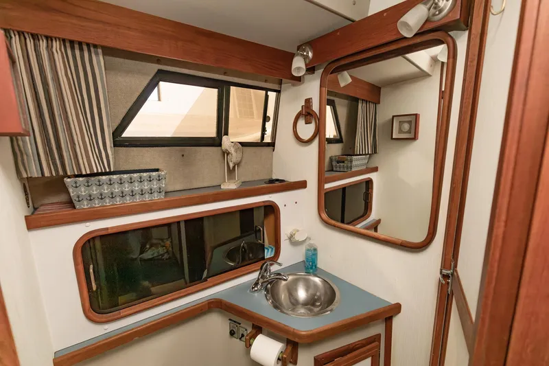 Slide: The Image of 1987 Carver 3697 Mariner bathroom with sink, mirror, and striped curtains. - 21
