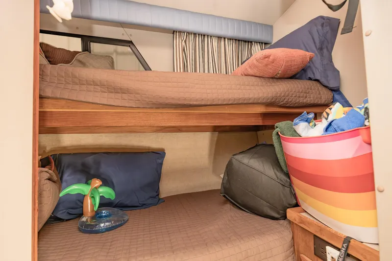 Slide: The Image of 1987 Carver 3697 Mariner cabin with cozy bunk beds and colorful decor. - 22