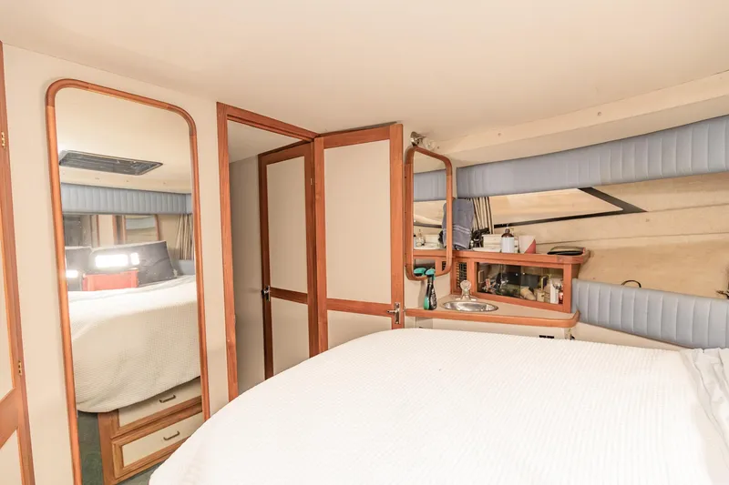 Slide: The Image of Interior of 1987 Carver 3697 Mariner yacht, featuring cozy bedroom with mirror and storage. - 28
