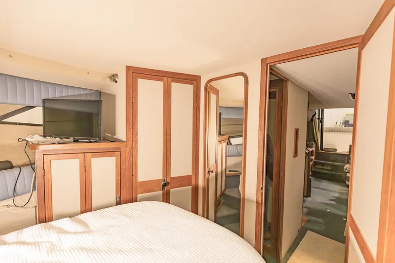 Slide: The Image of Interior of 1987 Carver 3697 Mariner yacht, featuring cozy bedroom and wooden cabinetry. - 31