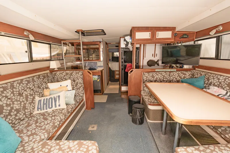 Slide: The Image of Interior of 1987 Carver 3697 Mariner boat with cozy seating and dining area. - 34