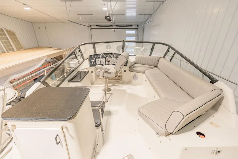 Slide: The Image of 1987 Carver 3697 Mariner boat interior with helm, seating, and controls in a storage facility. - 35