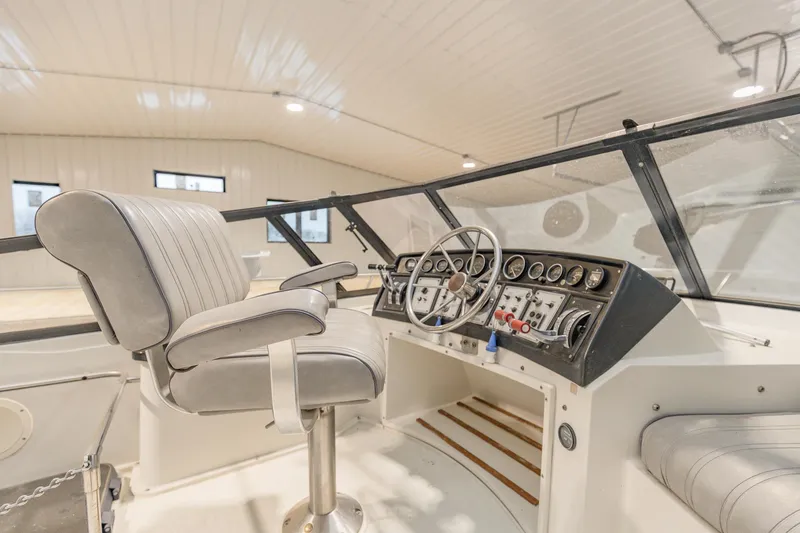 Slide: The Image of 1987 Carver 3697 Mariner helm with steering wheel and control panel in a bright cabin. - 37