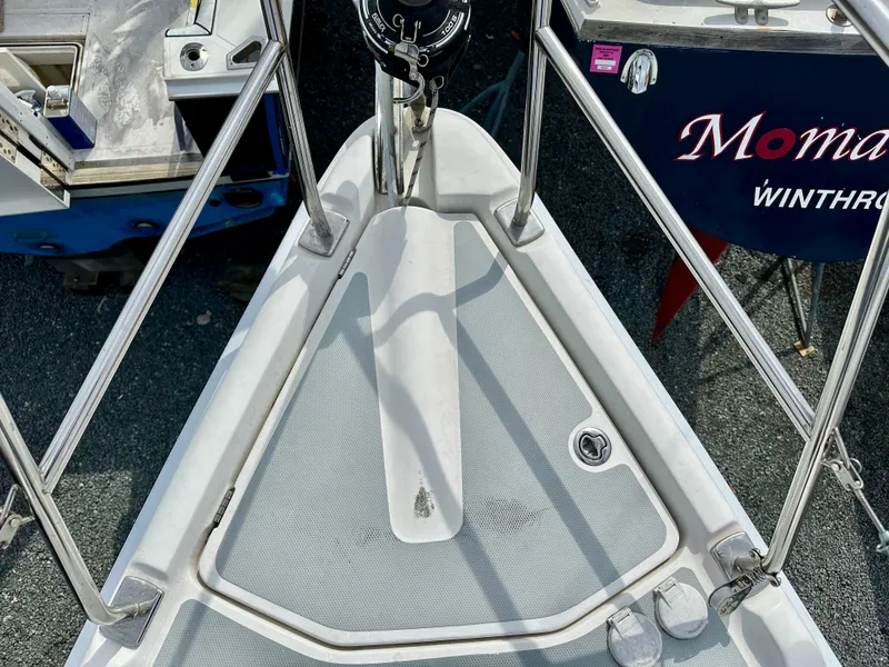 Slide: The Image of 2006 Hunter 31 sailboat deck view, showcasing rigging and hatches in a marina setting. - 11
