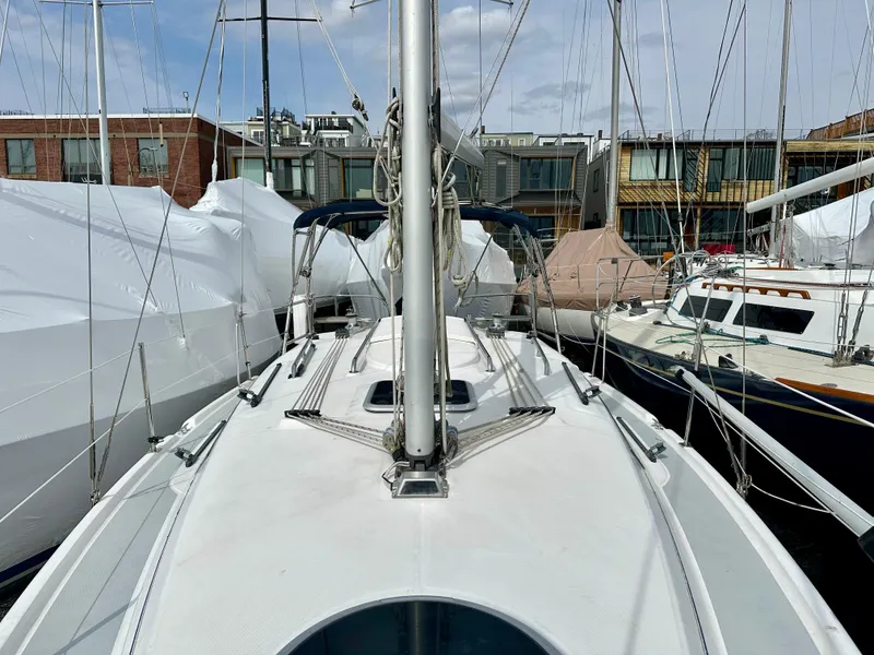 Slide: The Image of Bow of 2006 Hunter 31 sailboat with anchor, docked alongside other boats. - 13