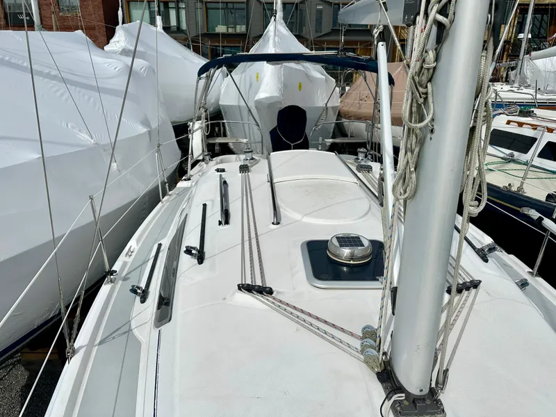 Slide: The Image of 2006 Hunter 31 sailboat docked at marina, surrounded by other boats. - 16