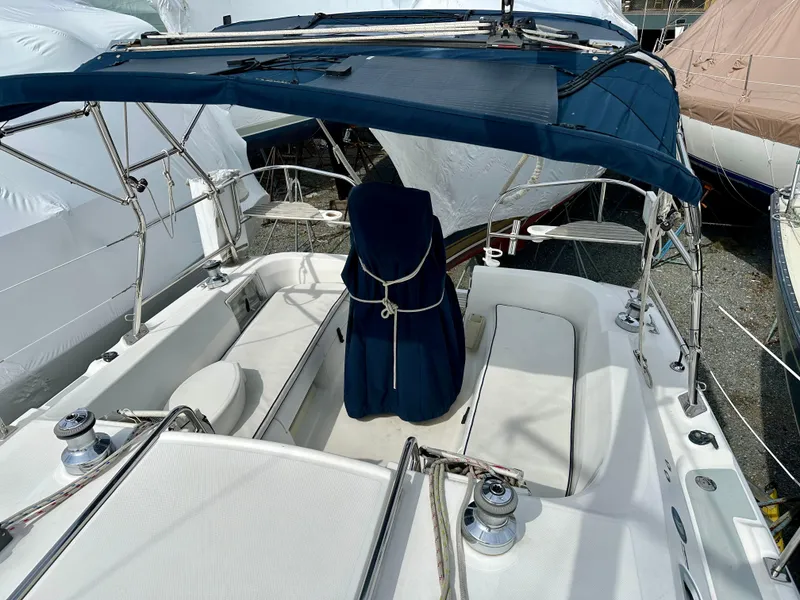 Slide: The Image of 2006 Hunter 31 sailboat deck with rigging, docked among other boats. - 18
