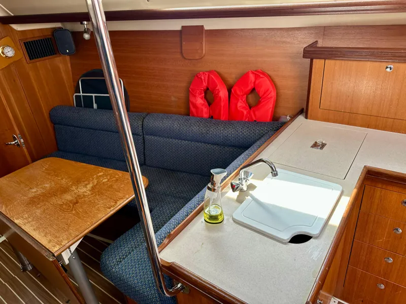 Slide: The Image of Interior of 2006 Hunter 31 sailboat with wooden paneling and blue cushioned seating. - 30