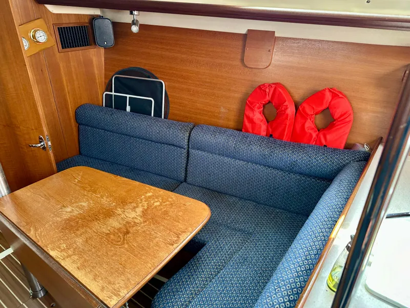 Slide: The Image of Interior of 2006 Hunter 31 sailboat with wooden paneling and blue cushioned seating. - 37