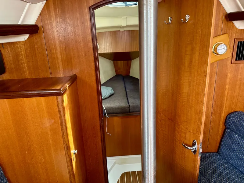 Slide: The Image of Cozy interior of 2006 Hunter 31 sailboat with blue seating and wooden table. - 38