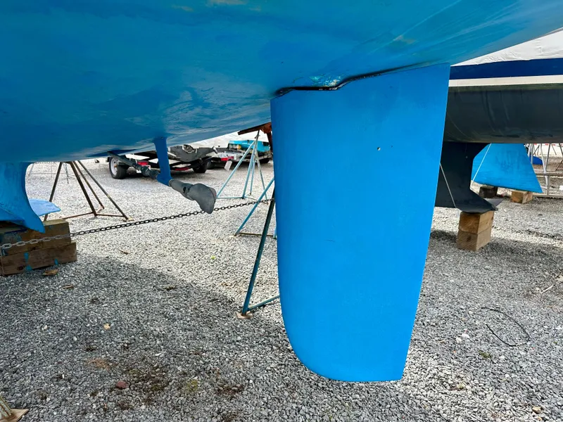 Slide: The Image of 2006 Hunter 31 sailboat propeller and rudder on dry dock, supported by stands. - 47