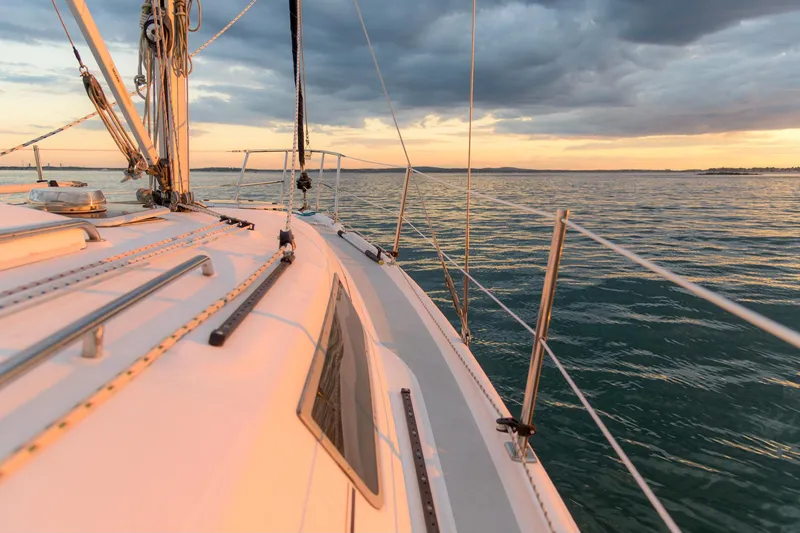 Slide: The Image of 2006 Hunter 31 sailboat on stands, white hull with blue stripe, in a boatyard. - 51