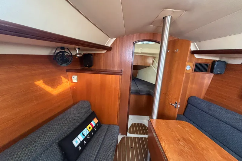 Slide: The Image of Interior of 2006 Hunter 31 sailboat with wood paneling and cozy seating area. - 60