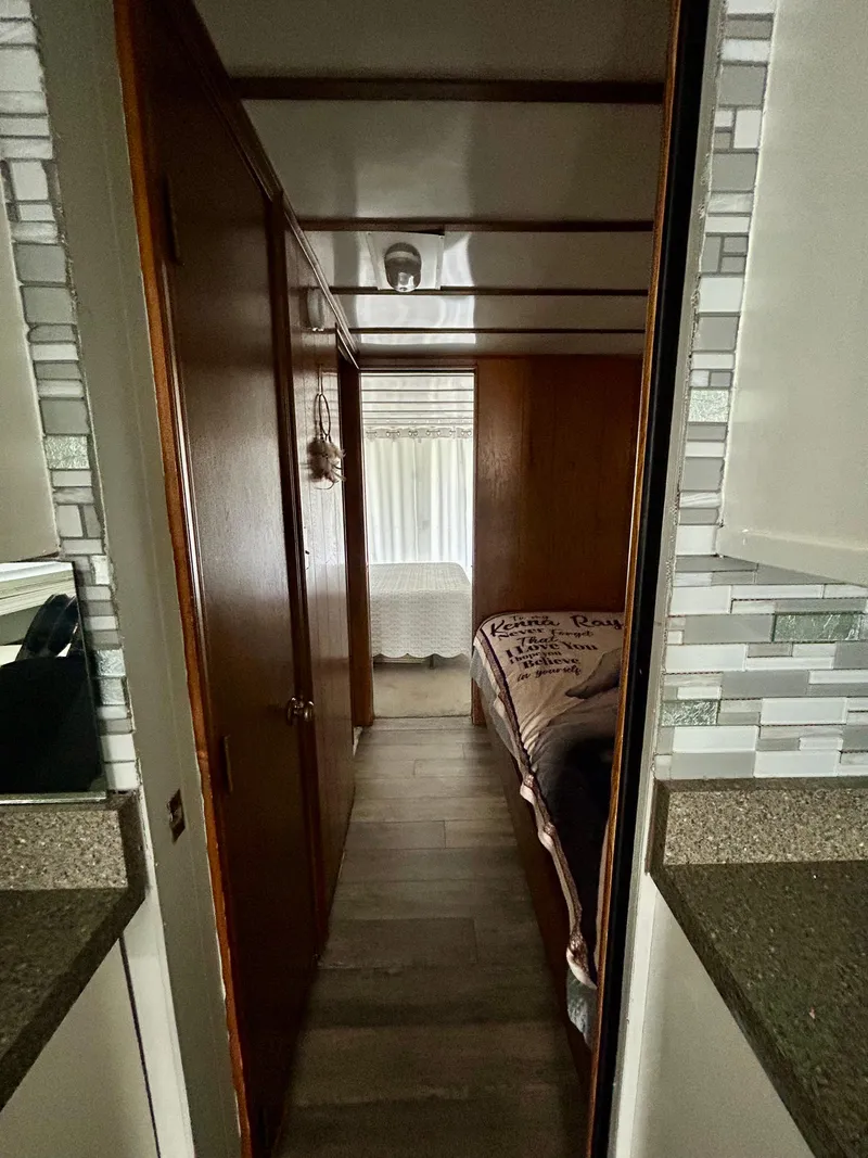 Slide: The Image of 1987 Jamestowner houseboat interior with wood paneling and cozy bedroom. - 12