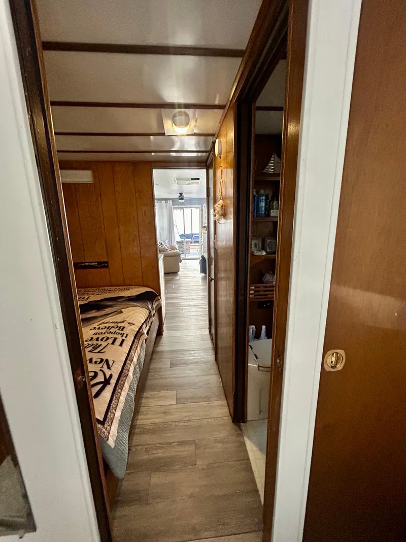 Slide: The Image of Interior hallway of a 1987 Jamestowner houseboat with wood paneling and cozy decor. - 13