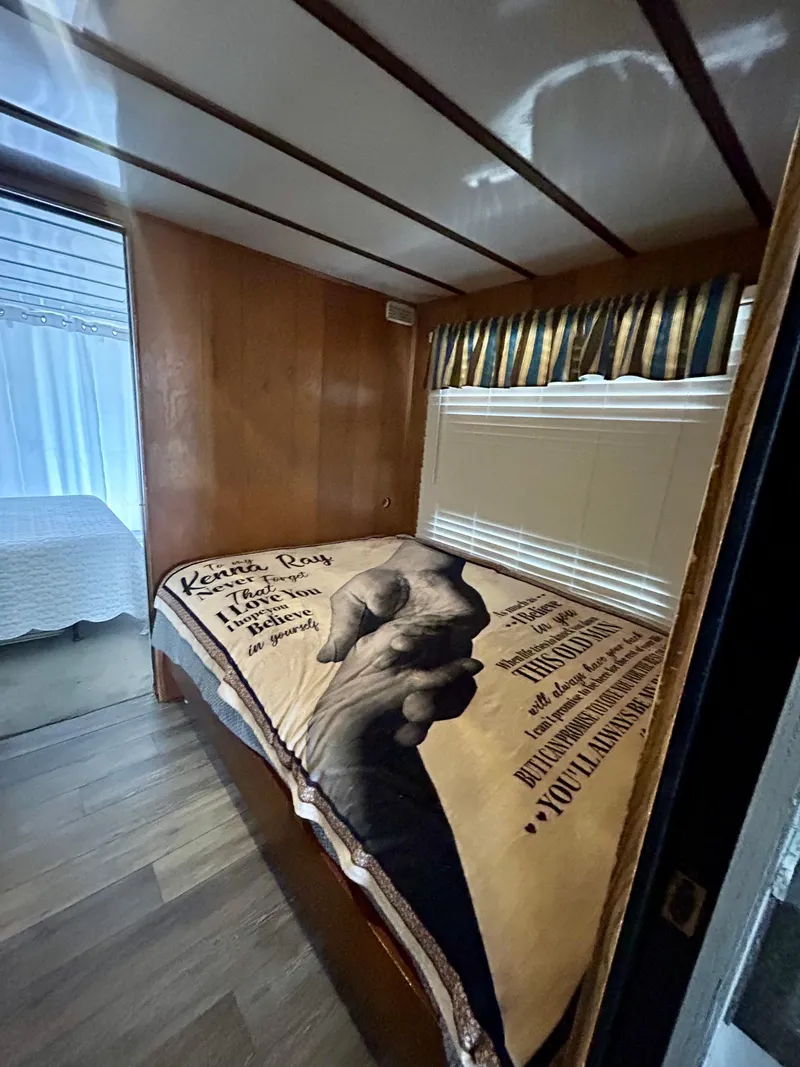 Slide: The Image of 1987 Jamestowner houseboat bedroom with wooden walls and a cozy bedspread. - 14