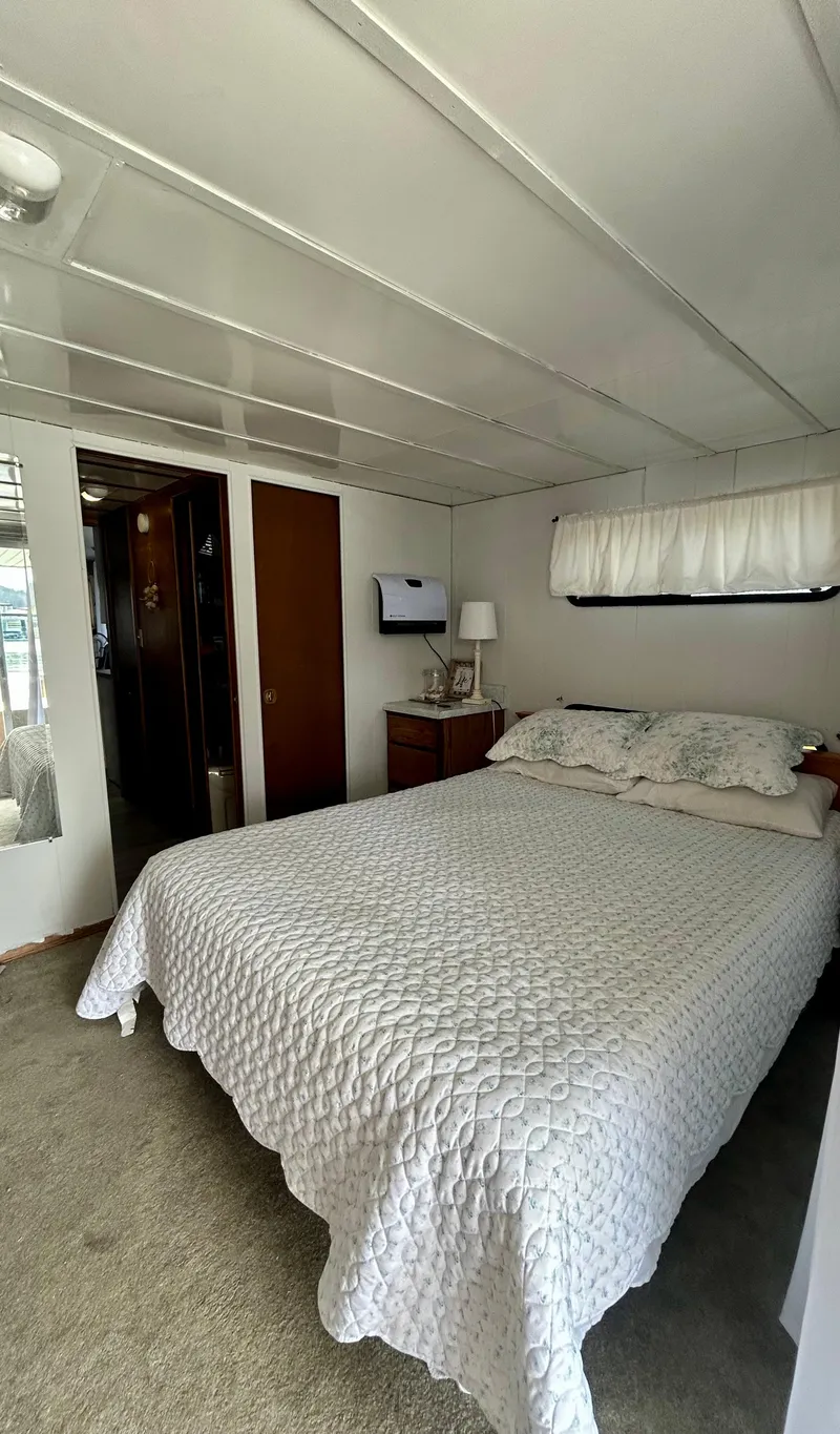 Slide: The Image of 1987 Jamestowner houseboat bedroom with cozy bed, white quilt, and small TV. - 17