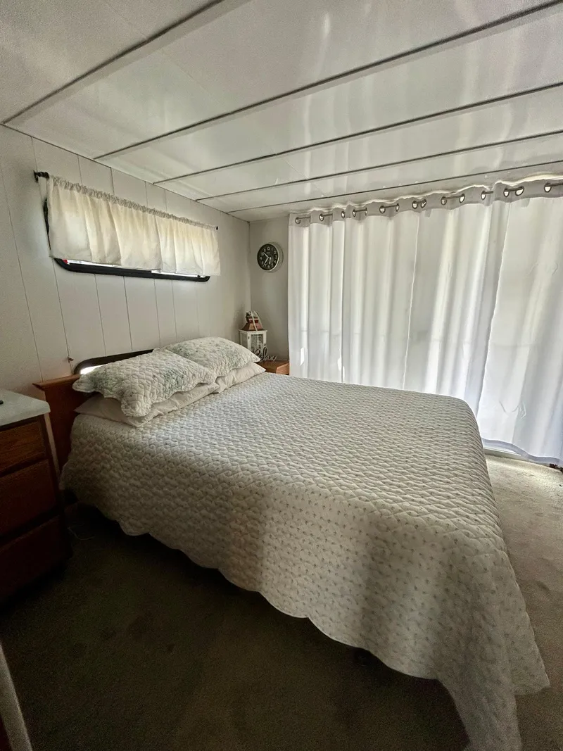 Slide: The Image of Bedroom interior of 1987 Jamestowner houseboat with bed and curtains. - 19