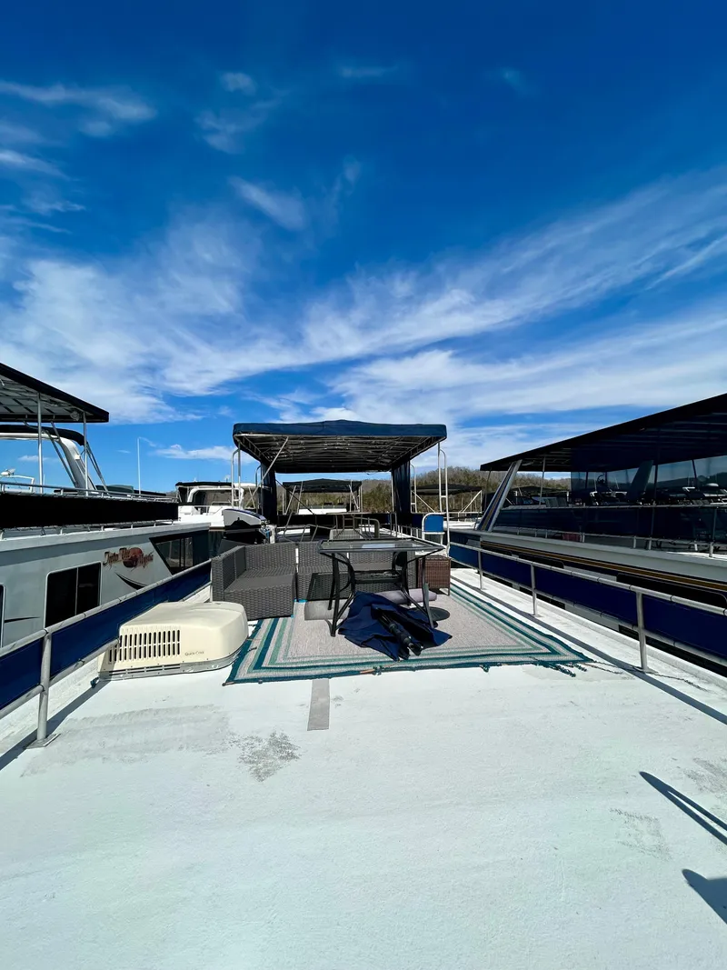 Slide: The Image of 1987 Jamestowner houseboat with spacious deck, outdoor seating, and clear blue sky. - 20