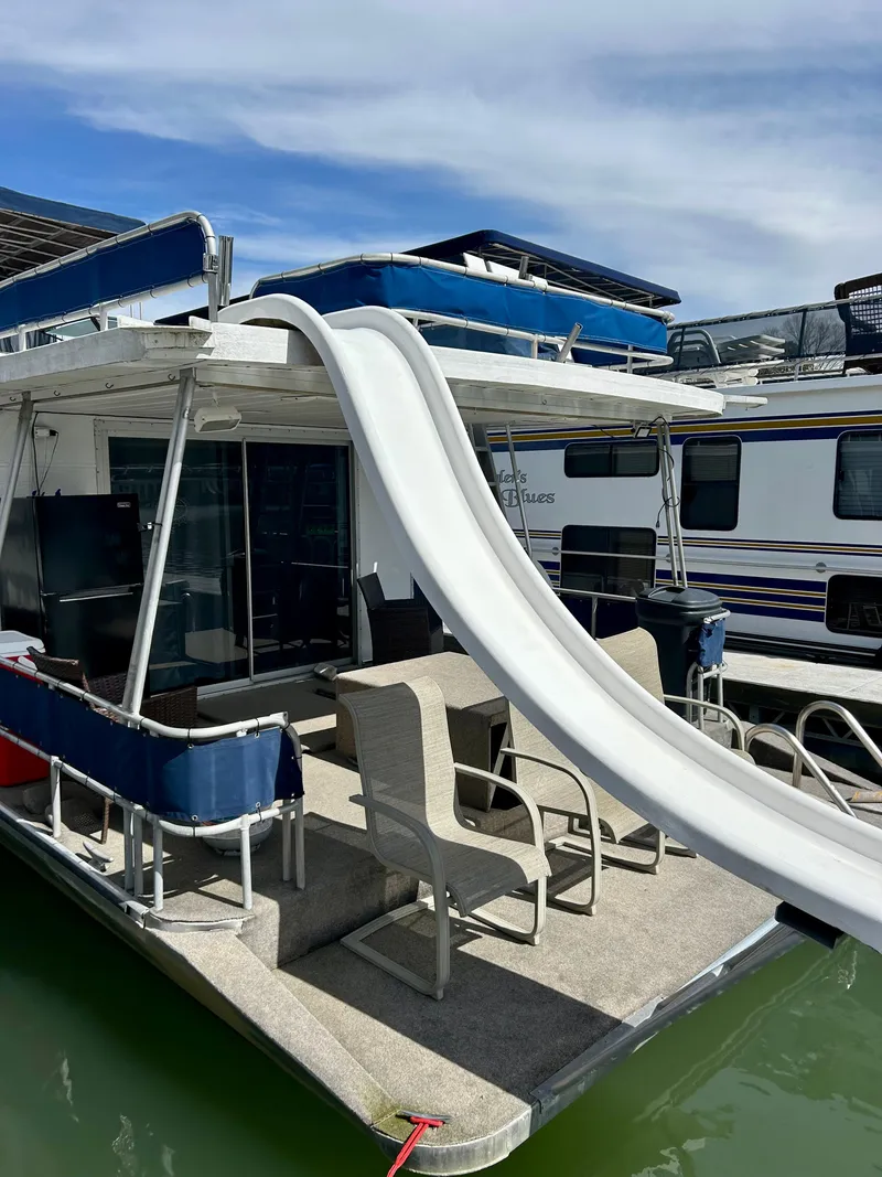 Slide: The Image of 1987 Jamestowner houseboat with slide, docked on calm water under a clear sky. - 23