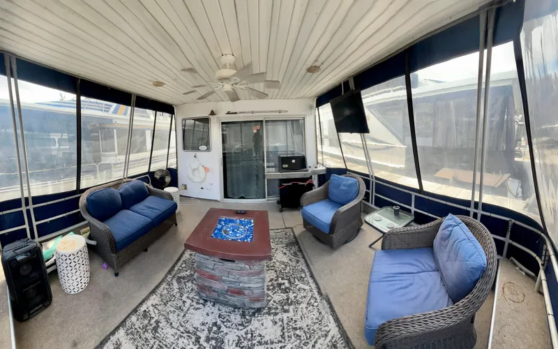 Slide: The Image of 1987 Jamestowner houseboat interior with cozy seating, ceiling fan, and panoramic windows. - 3