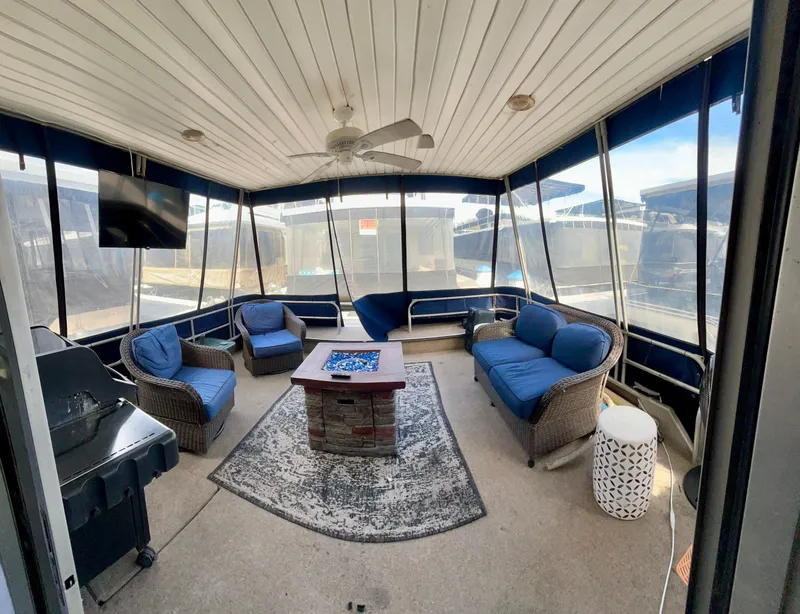 Slide: The Image of 1987 Jamestowner houseboat interior with wicker furniture, ceiling fan, and grill. - 5